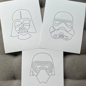 May include: Three black and white line drawings of Star Wars characters: Darth Vader, a Stormtrooper, and Kylo Ren. The drawings are on white paper.