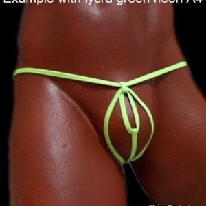 May include: Neon green lycra thong underwear. The thong features a unique design with a central loop and thin straps. The fabric appears smooth and form-fitting, highlighting the garment's minimalist style.