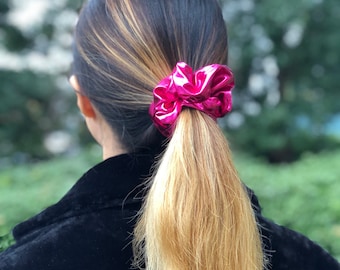 May include: A pink metallic scrunchie for hair.