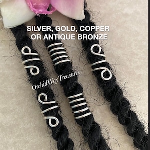 May include: Close-up of black dreadlocks adorned with silver metal hair beads. The image features various styles of hair jewelry, including spiral and coiled designs. Text at the top reads "SILVER, GOLD, COPPER OR ANTIQUE BRONZE".