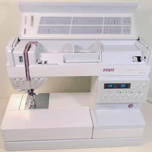 Può includere: Macchina da cucire bianca Pfaff Creative 1475 con vano portaoggetti integrato e display digitale. La macchina ha una varietà di opzioni di cucitura e una luce integrata. Progettata per progetti di cucito e artigianato.
