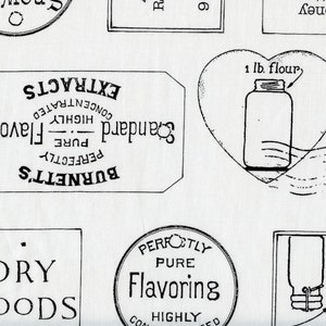 May include: A white fabric with a repeating pattern of vintage-style labels and illustrations. The labels feature text like "Dry Goods," "Flavoring," and "Extracts." A heart-shaped illustration contains a jar labeled "1 lb. flour."