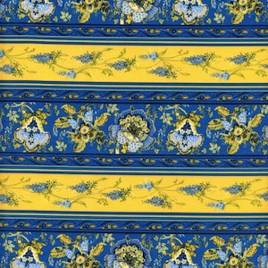 May include: A repeating pattern of blue and yellow floral stripes. The design features large blue flowers with yellow and green accents, alternating with yellow stripes adorned with smaller blue floral sprigs. The background is a bright blue.