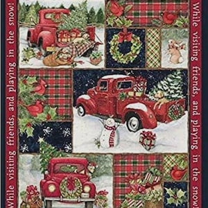 May include: A Christmas-themed quilt featuring red trucks, wreaths, and gifts in a snowy landscape. The quilt has a patchwork design with text that reads "Take a little Christmas with you, Wherever you go!" and "While visiting friends, and playing in the snow!"