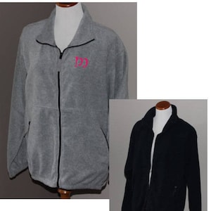 May include: Two fleece jackets displayed on mannequins. One is gray with a black zipper and the pink letters "DD" embroidered on the chest. The other is black with a black zipper. Both jackets have a high collar and side pockets.