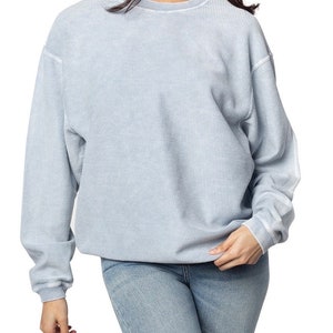 May include: A light blue waffle knit sweatshirt with a relaxed fit and long sleeves.