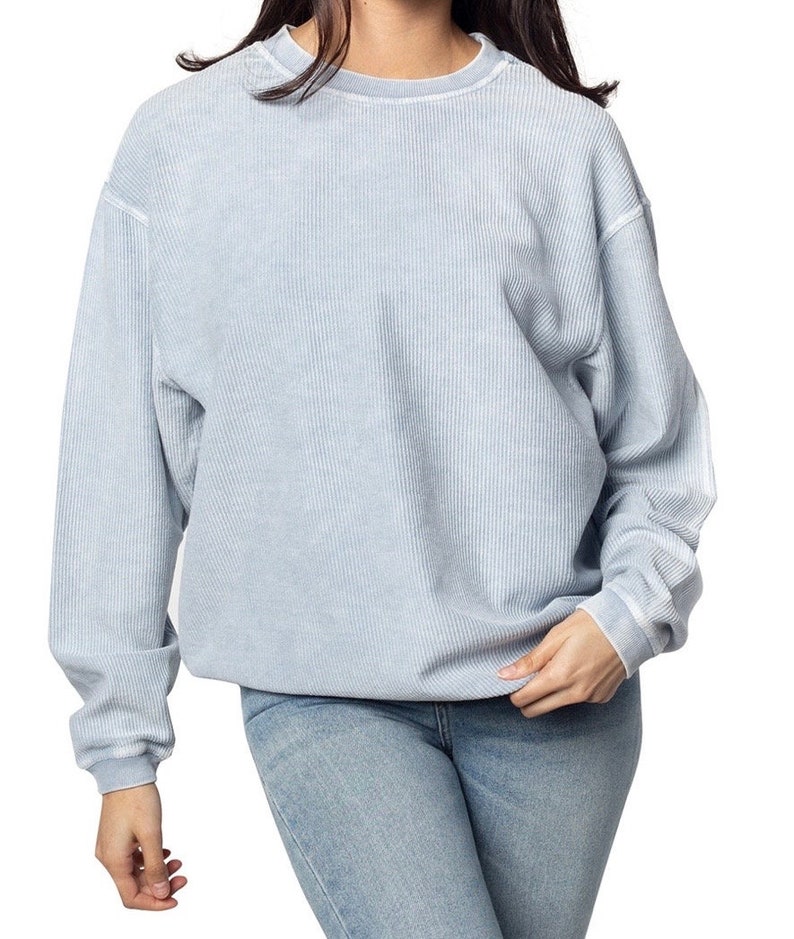 May include: A light blue waffle knit sweatshirt with a relaxed fit and long sleeves.