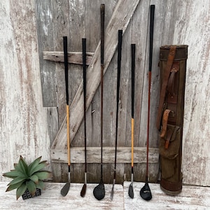 May include: A white ceramic mug with a black handle and the text "But First, Coffee" in a handwritten style. The mug is on a white surface. The mug is approximately 4 inches tall.