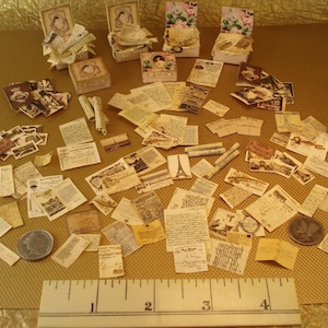 Può includere: Una collezione di ephemera di carta vintage, tra cui lettere, cartoline e buste, con una varietà di disegni e colori. Le ephemera di carta sono disposte su una superficie marrone con un righello per la scala.