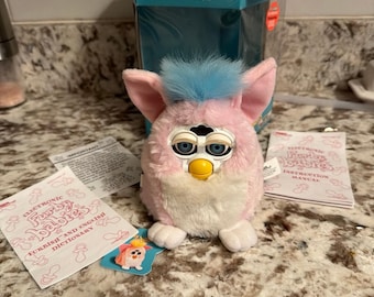 Furby rosa, blanco y azul de 1999. ¡Todavía funciona! Excelente estado con caja.
