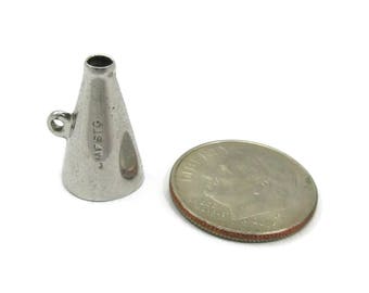 May include: A silver charm in the shape of a megaphone. The charm is about the size of a US dime. The charm has the inscription "MFSTC" on the side.