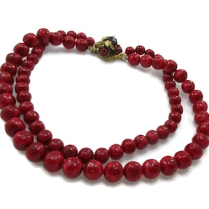Può includere: Una collana a doppio filo realizzata con perle di corallo rosso con una chiusura in oro e smalto.