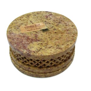 May include: A round, yellow and brown stone box with a carved design around the bottom edge. The box has a label that reads "Crowning Touch Imports" and "Made in India".