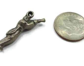 May include: Silver charm of a person playing a musical instrument, approximately the size of a US dime.