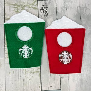 May include: Two felt coffee cup decorations, one green and one red, with white foam tops and a white embroidered logo.