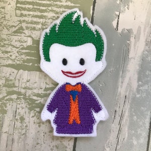 May include: An embroidered felt patch of the Joker from Batman. The patch is white with a green mohawk, purple jacket, orange tie, and a red smile.