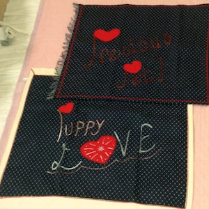 May include: Two blue fabric squares with white polka dots and red hearts. The top square has the text "Precious You!" and the bottom square has the text "Puppy Love".