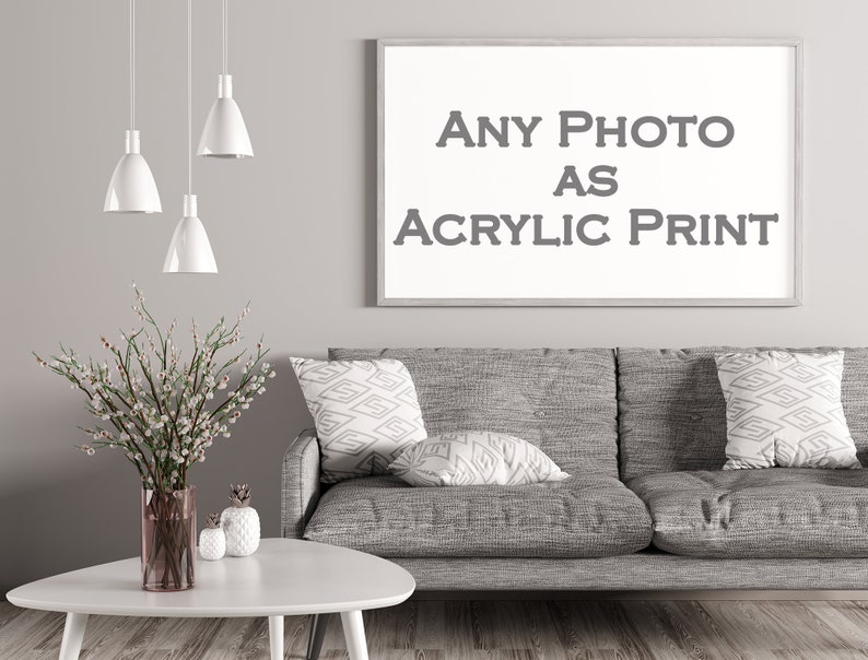 May include: A gray couch with three throw pillows, a white coffee table, and a vase with white flowers. A framed picture on the wall reads "ANY PHOTO AS ACRYLIC PRINT".