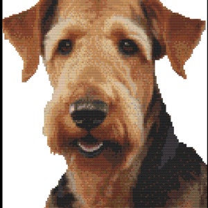 May include: A close-up of a cross-stitch portrait of a dog, featuring a brown and black color scheme. The dog's face is detailed, with visible eyes, nose, and mouth. The background is white.