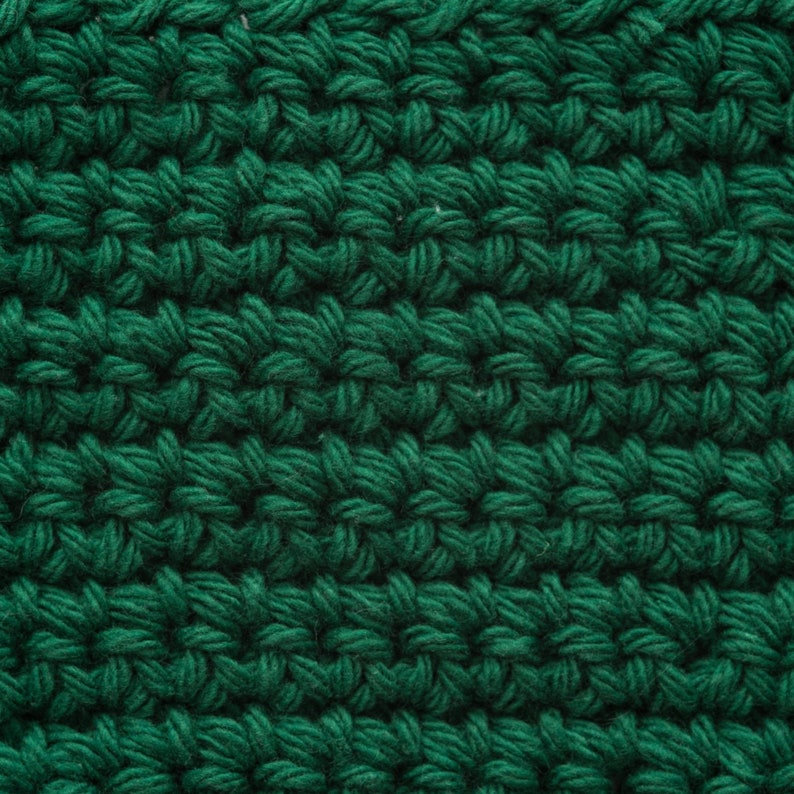 May include: Close-up of a green crocheted fabric with a textured, woven pattern.