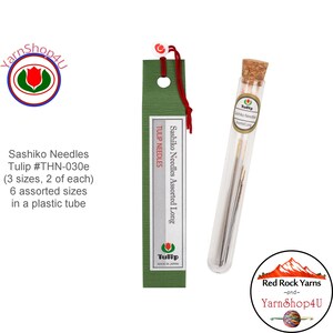 May include: Sashiko needles by Tulip, assorted long, in a clear plastic tube with a cork stopper. The needles come in 6 assorted sizes. The packaging includes a green and silver sleeve with the text "Tulip Needles".