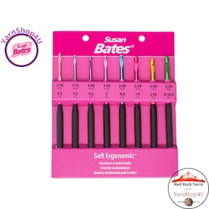 May include: A set of Susan Bates Soft Ergonomic aluminum crochet hooks in a pink package. The hooks range in size from 3.50 mm (E-4 US) to 6.50 mm (K-10.5 US) and feature black ergonomic handles. The package includes the text "Soft Ergonomic".