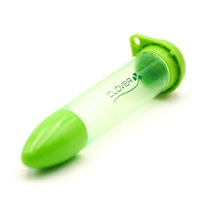 May include: A green and clear Clover needle case. The case is cylindrical with a rounded green tip and a green cap with a small hole. The Clover logo and a shamrock are printed on the clear tube.