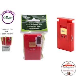 May include: A red Clover knitting counter, with a white dial and a sliding button. The package includes the text "Knitting Counter" in multiple languages. The Clover logo is visible on the counter and the packaging.