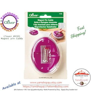 May include: A Clover #4105 Magnet Pin Caddy in a package. The oval-shaped, magenta-colored caddy holds pins with red heads. The package includes text in English, French, Spanish, and German. The caddy is designed to hold pins for sewing and crafting.