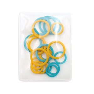 May include: A clear plastic bag filled with various sizes of yellow and teal-colored rubber rings. The rings are scattered throughout the bag, creating a colorful and playful display. The bag is sealed and ready for use.