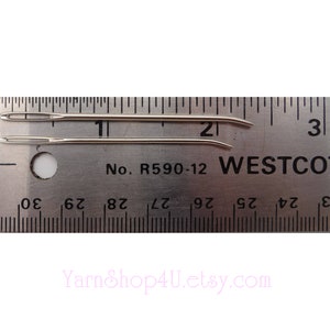 May include: Two silver needles measuring 2 inches long, laid out on a ruler with the text "No. R590-12 WESTCO" printed on it.