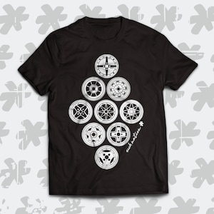 Puede incluir: Camiseta negra con un gráfico blanco de varias llantas de coche dispuestas en forma de diamante. El texto "sick nation" está impreso en la esquina inferior derecha del gráfico.