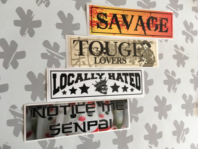 Op de afbeelding: Vier stickers met verschillende ontwerpen. De bovenste sticker is geel met rode en zwarte tekst die "SAVAGE" zegt. De tweede sticker is beige met zwarte tekst die "TOUGE LOVERS" zegt en een zwart-witte illustratie van een persoon. De derde sticker is wit met zwarte tekst die "LOCALLY HATRED" zegt en een zwart-witte illustratie van een schedel met een kroon. De onderste sticker is wit met zwarte tekst die "NOTICE ME SENPAI" zegt en een wazig beeld van een knuffeldier.