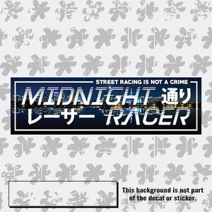 Op de afbeelding: Zwart-witte sticker met de tekst "STREET RACING IS NOT A CRIME" en "MIDNIGHT 通り レーサー RACER" met een stadsachtergrond.