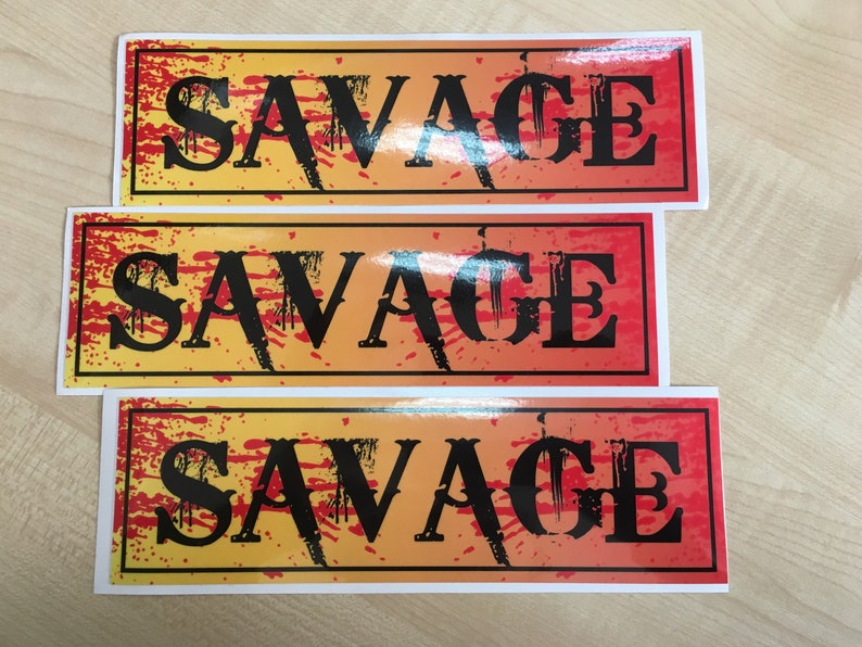 Op de afbeelding: Drie rechthoekige stickers met een gele en rode gradi&euml;nt achtergrond. De stickers hebben een zwarte rand en het woord "SAVAGE" in zwarte vetgedrukte letters.