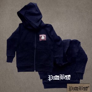 May include: Black zip-up hoodie with a skull and crossbones patch on the front and "Punk Baby" printed on the back.