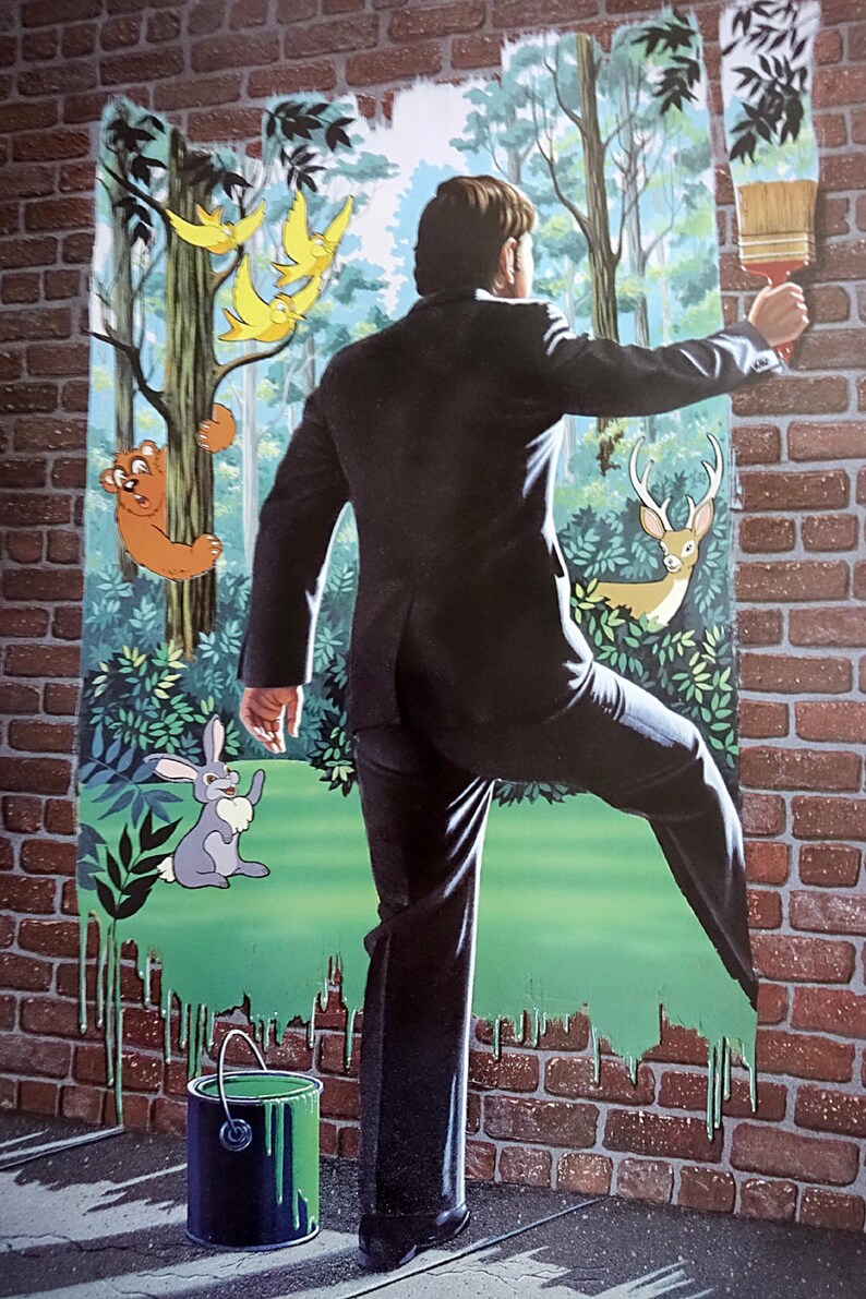 May include: A man in a black suit paints a brick wall with a green paintbrush. The wall is being transformed into a forest scene with a bear, a rabbit, a deer, and birds.