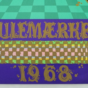 May include: A vintage poster with the text "JULEM&AElig;RKET 1968" in gold lettering. The poster features a purple background with a checkered pattern in the centre and a green checkered pattern at the top. The overall design has a retro aesthetic.