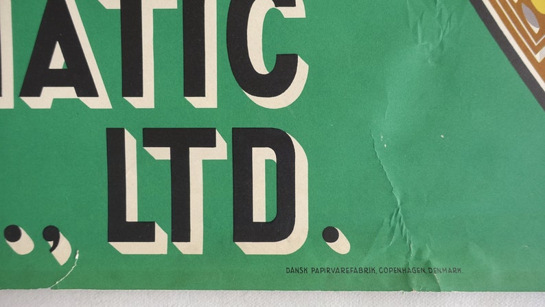May include: A green poster with the text "MATIC LTD." in black and white lettering. The text "DANSK PAPIRVAREFABRIK, COPENHAGEN DENMARK" is printed in black at the bottom of the poster.
