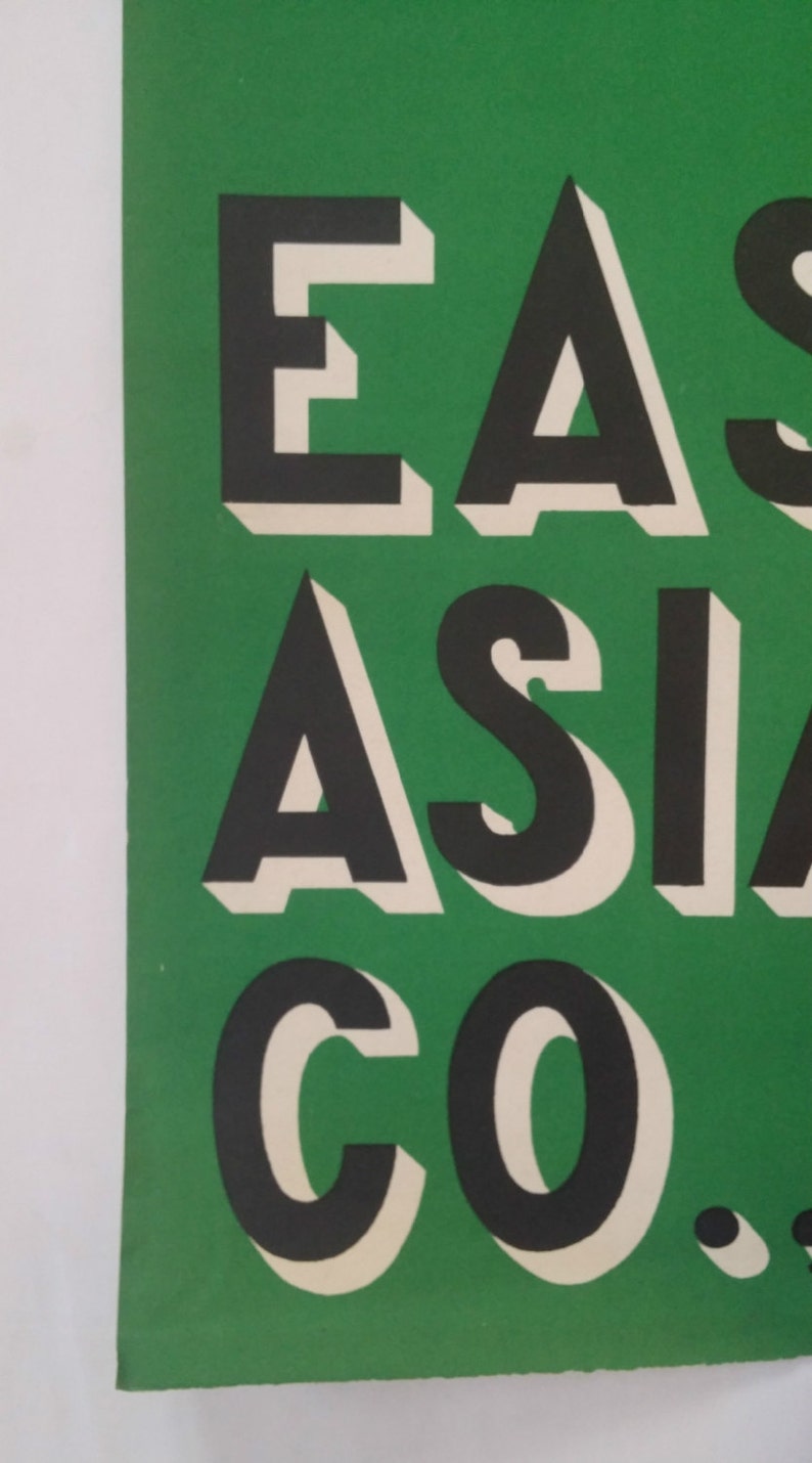 May include: A green poster with the text "EAST ASIA CO." in black and white letters with a 3D effect.