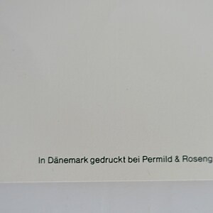 Op de afbeelding: Een witte achtergrond met de tekst "In D&auml;nemark gedruckt bei Permild & Rosengreen" in het groen gedrukt.