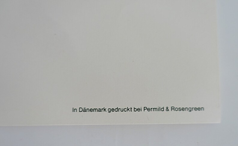 Op de afbeelding: Een witte achtergrond met de tekst "In D&auml;nemark gedruckt bei Permild & Rosengreen" in het groen gedrukt.
