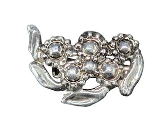 Broche vintage florale argentée avec motif texturé de pétales et de feuilles