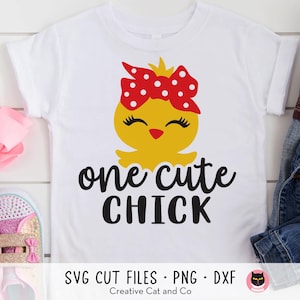 Könnte beinhalten: Ein weißes T-Shirt mit einem gelben Küken, das eine rote Schleife mit weißen Punkten trägt. Der Text "one cute chick" ist in Schwarz unter dem Küken aufgedruckt.