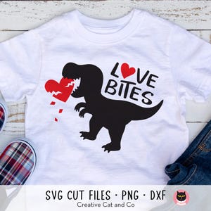 May include: White t-shirt with a black dinosaur silhouette biting a red heart. The text "Love Bites" is written in red above the dinosaur.