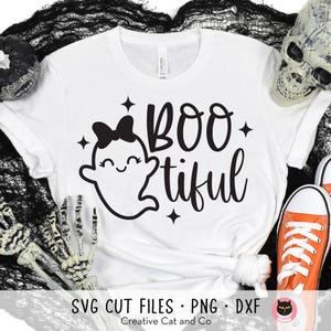 May include: White t-shirt with a black ghost wearing a bow and the text "BOO-tiful".