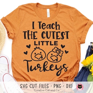 May include: Orange t-shirt with black text that reads "I Teach The Cutest Little Turkeys". The text is surrounded by hearts and two cartoon turkeys.