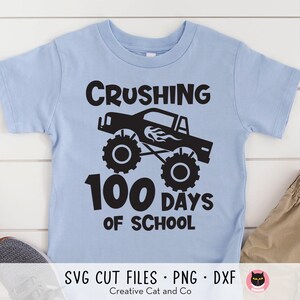 May include: A light blue t-shirt with a black graphic of a monster truck and the text "Crushing 100 Days of School".