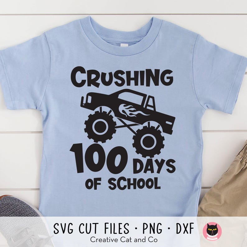 May include: A light blue t-shirt with a black graphic of a monster truck and the text "Crushing 100 Days of School".