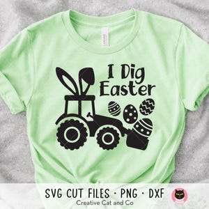 May include: A pale green t-shirt with a black graphic. The design shows a tractor with bunny ears and the text "I Dig Easter" with Easter eggs. The words "SVG CUT FILES • PNG • DXF" are below the graphic.